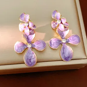 Detailed view of purple oil-drop flower earrings with sparkling rhinestone center