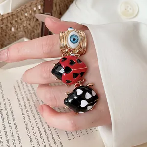 Exquisite macro detail of ladybug enamel drip rings and golden evil eye adjustable ring set