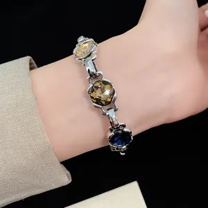 Close-up of vintage bracelet with faceted amber and blue crystals on wrist