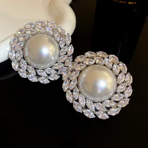 Detailed macro view of elegant pearl stud earrings with sparkling marquise zircon