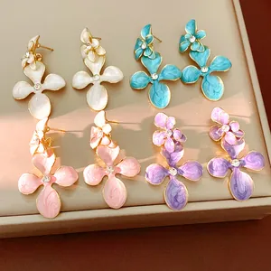 Detailed view of colorful enamel flower earrings with rhinestone centers in four shades.