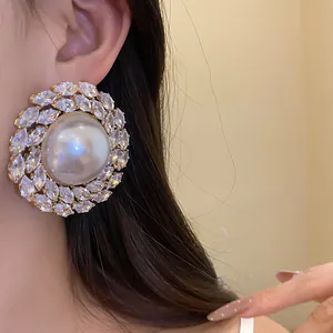Macro view of elegant vintage-style zircon stud earring with large pearl on model's ear