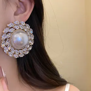 Close-up of vintage luxury round pearl stud earring with sparkling marquise zircons