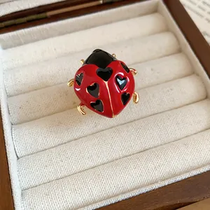 Unique ladybug open ring featuring red enamel and black heart details in a jewelry box