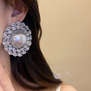 Close-up of a luxury stud earring with a large pearl and sparkling zircon halo.