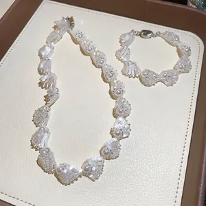 Elegant pearl and shell bead necklace and bracelet jewelry set on display tray