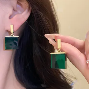 Close-up of vintage-style green square resin drop earrings with gold-tone hardware.