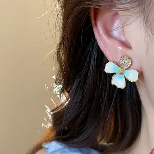 Dettaglio dell'orecchino a fiore smaltato bianco e blu con zirconi