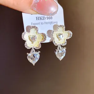 Elegant heart-shaped flower stud earrings featuring shimmering crystals and a light luxury style.