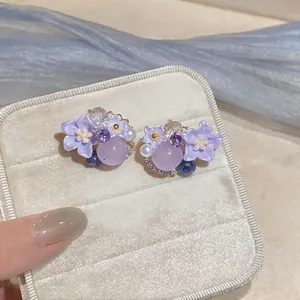 Elegant detail view of handmade purple floral earrings with pearl and crystal accents