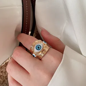 Close-up macro detail of the evil eye pattern on a gold-plated open adjustable ring