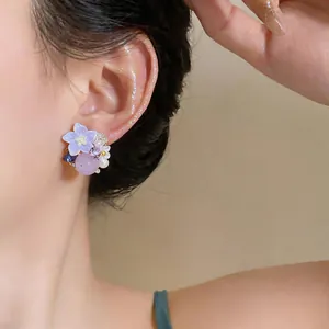 Macro view of elegant purple forest-style flower earrings with mini pearls