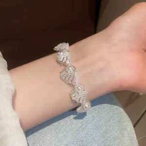 Detailed close-up showing an elegant pearl and shell beaded bracelet on a woman's wrist