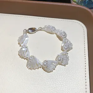 Elegant white shell and pearl beaded bracelet detailed view on beige display tray