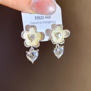 Close-up of elegant heart-shaped flower drop earrings with sparkling clear cubic zirconia