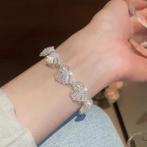 Close-up detail of an elegant white beaded pearl shell bracelet worn on a female wrist.