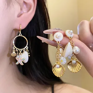 Primer plano de pendientes de perlas y conchas con dijes de estrella de mar estilo playa