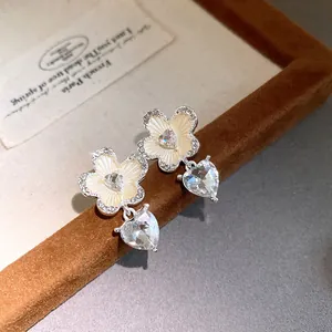 Exquisite floral earrings with a sparkling heart-shaped crystal pendant detail