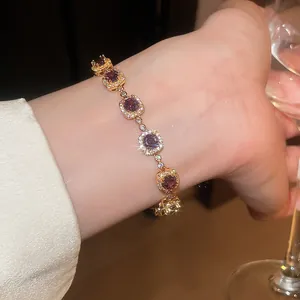Stunning detail of an 18k gold plated bracelet featuring square purple zircons.