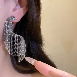 Vista detallada de pendientes de borla geométricos de plata con cadenas de cuentas
