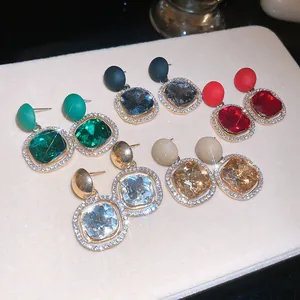 Detail view of colorful crystal drop earrings with matte round studs in elegant layout