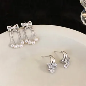 Elegant silver bow pearl tassel and crescent moon crystal stud earring set on white plate