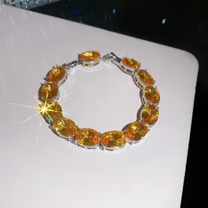 Close-up of 18k gold plated bracelet with yellow oval zircons and sparkling effect.