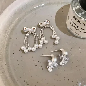 Elegant silver needle bow-knot earrings with pearl tassels and crystal cluster details