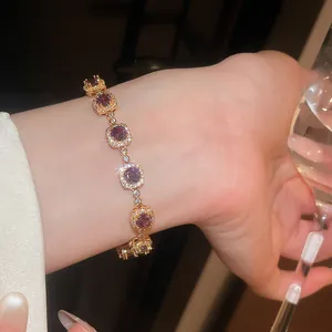 Close-up of elegant 18k gold plated bracelet with purple zircons on wrist