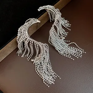 Primer plano detallado de elegantes pendientes geométricos de plata con borlas de cuentas