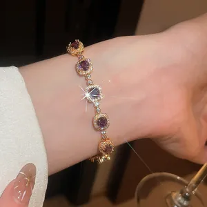 Close-up of elegant 18k gold plated bracelet with sparkling purple zircons on wrist