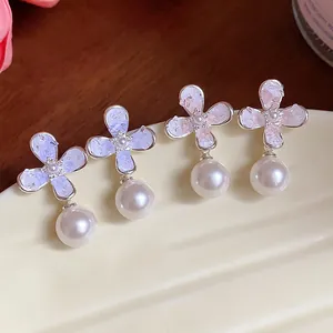Dettaglio degli orecchini con fiori e perle in stile francese ed eleganti cristalli.