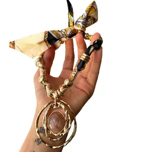 Bohemian vintage style fabric necklace with round resin pendant and gold metal rings