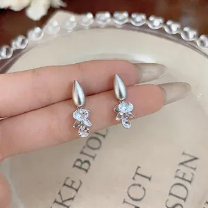 Detailed macro shot of elegant silver drop earrings featuring sparkling crystal floral clusters