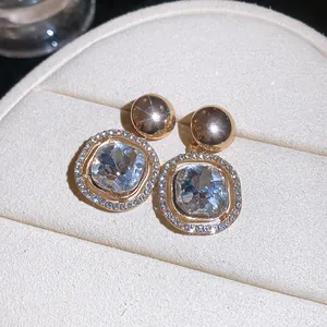 Close-up of geometric halo crystal earrings with a sparkling starburst effect