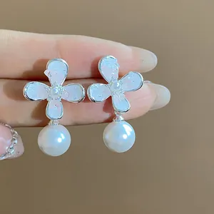 Primo piano dettagliato di eleganti orecchini a fiore in argento con perle pendenti