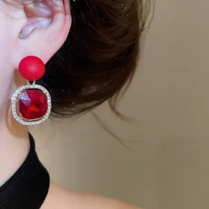 Elegant red geometric earrings with sparkling rhinestone border for a chic look.