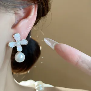 Dettaglio di un orecchino francese con fiore e perla, che mostra texture eleganti.