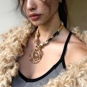 Detailed macro shot of a resin round pendant necklace worn by a fashion model in a fuzzy coat