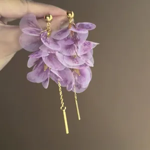 Vista dettagliata di orecchini a petalo viola con lunghi accenti di nappa