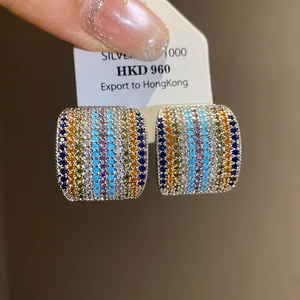 Detailed macro view of vintage square stud earrings with colorful pavé zircons and silver needle