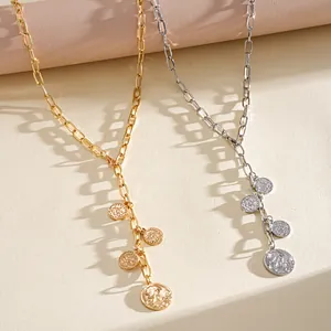 Detailed view of gold and silver retro coin pendant necklaces with paperclip chains