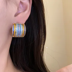 Close-up of vintage square stud earrings featuring colorful multi-row striped zircon stones