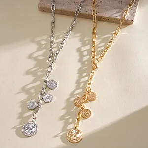 Detailed view of vintage gold and silver coin pendant necklaces with chunky metal chains.