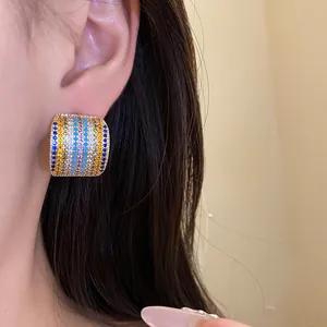 Close-up view of vintage square stud earrings with colorful pavé zircons on ear