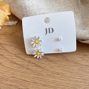 Minimalist sweet enamel daisy and pearl stud earring set presented on a white card