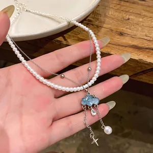 Elegant blue cloud pendant pearl necklace with zircon teardrop held in hand for display