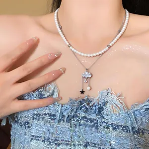 Close-up detail of a layered necklace with elegant pearls and a blue cloud zircon pendant.