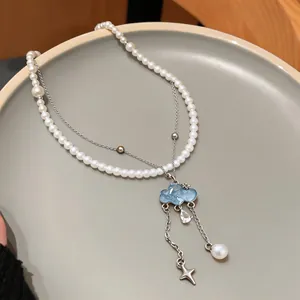 Detail of a blue cloud pendant necklace with zircon water drop and white pearls