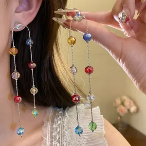 Close-up of elegant multicolored glass bead long dangling earrings worn by a model